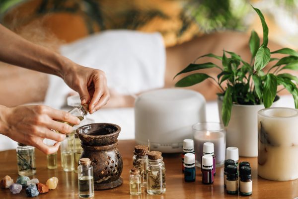 Ayurveda aromatherapy massage, female hand pouring aromatic oil in an essential oil diffuser