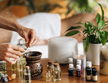Ayurveda aromatherapy massage, female hand pouring aromatic oil in an essential oil diffuser